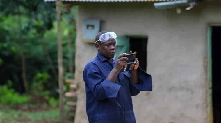 Medium Shot Of Benard Taking A Video Of Shelling Using His Phone To Use It For Digital Marketing